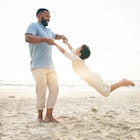 A father and son playing together on a beach in Cancún